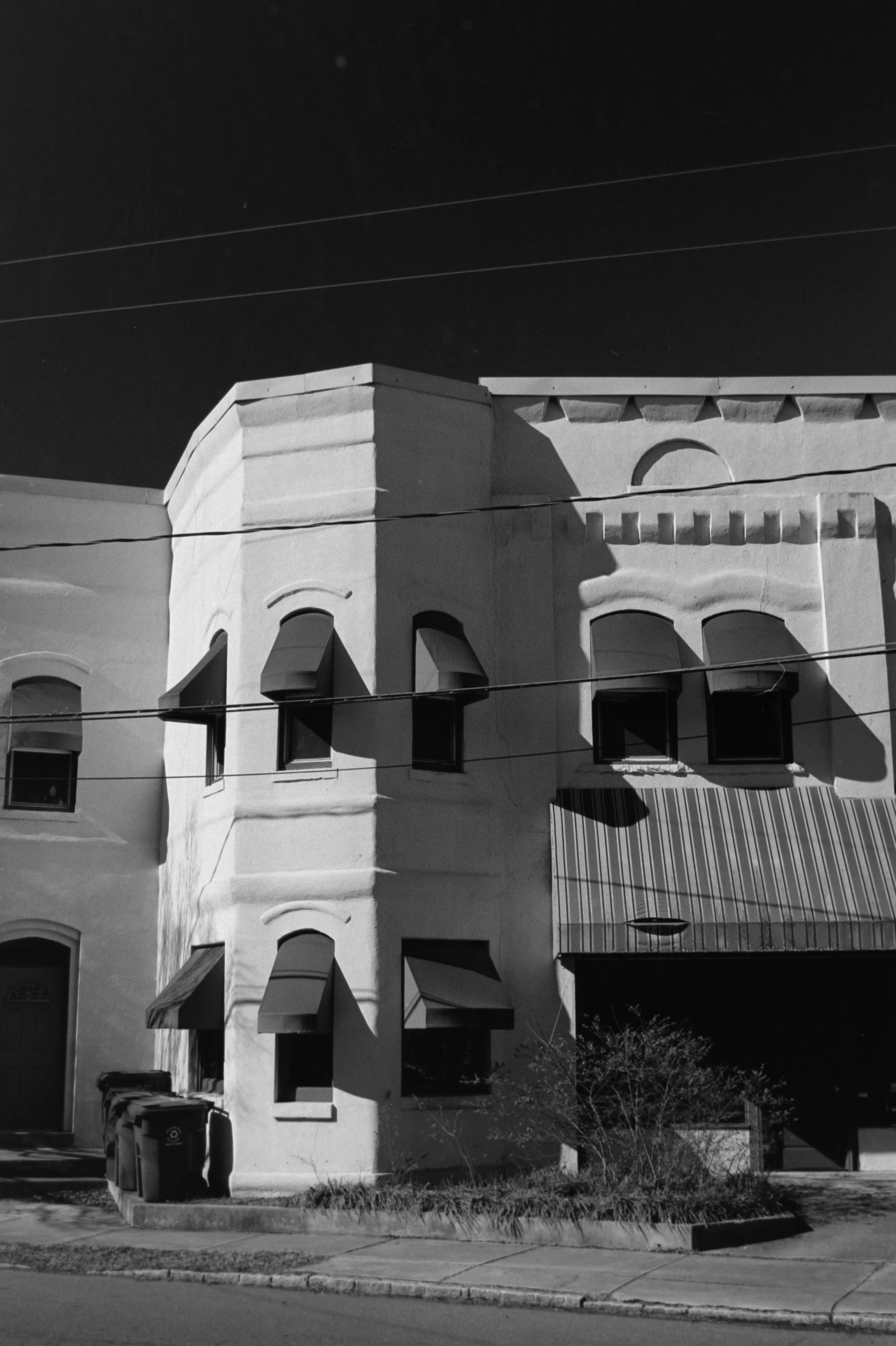 White stucco storefront with deep shadows